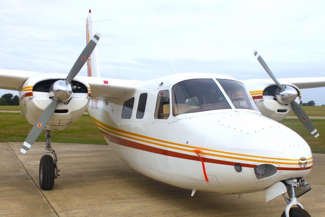 Front side view of Aero Commander 500 N711NE with twin propellers