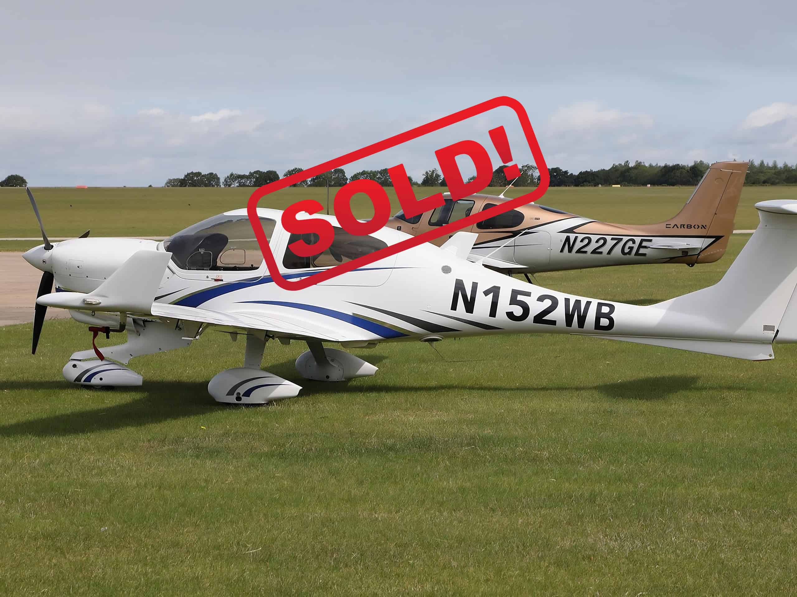 Diamond DA40NG N152WB 2019 aircraft left side view on grass with Cirrus aircraft in background