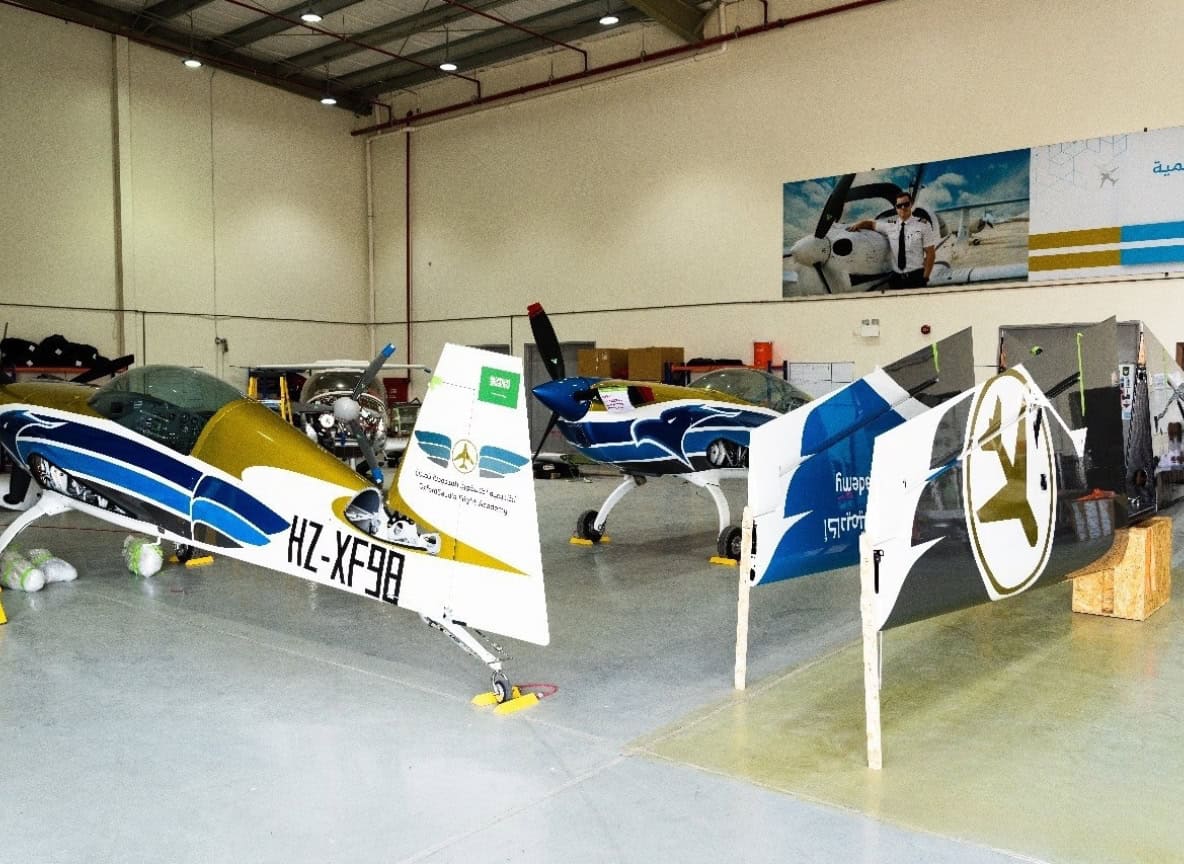 Extra 330LX HZ-XF98 aerobatic aircraft in hangar with custom blue and gold paint scheme